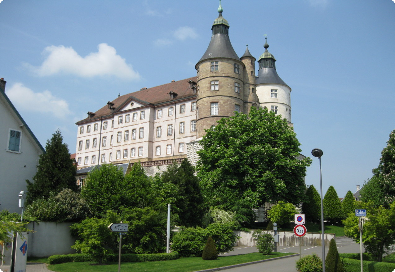 Vue extérieure du Château de Montbéliard avec ses tours Renaissance et son jardin arboré.