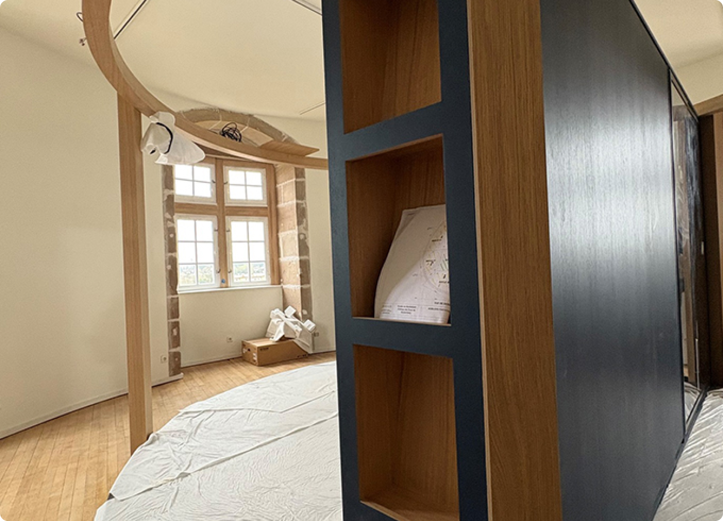 image_1_mobilier Salle d’exposition en cours d’installation dans un musée, avec mobilier scénographique en bois et structures modernes.