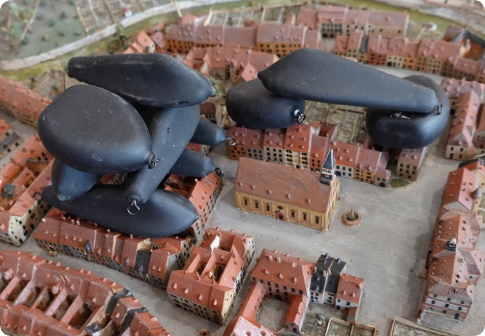 image_3_restauration Installation artistique contemporaine en mousse noire sur une maquette de la ville de Montbéliard.