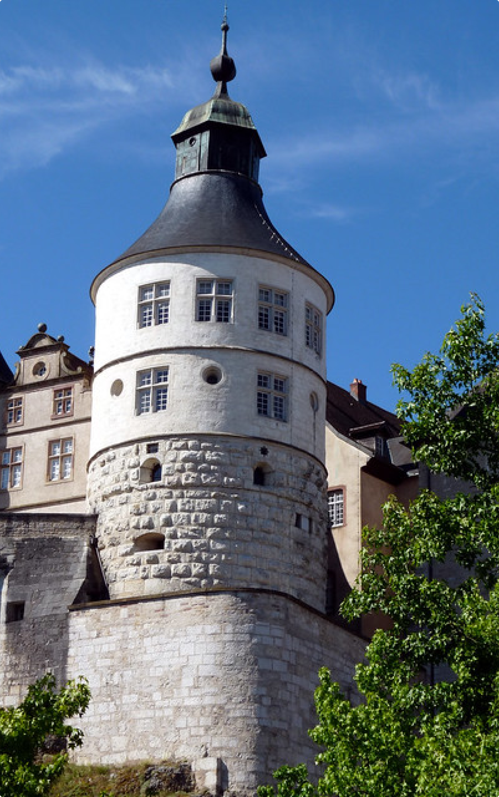 Tour Henriette du Château de Montbéliard, vue en contre-plongée sous un ciel bleu.